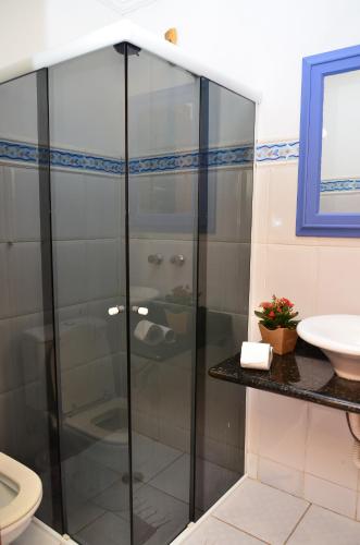 a glass shower in a bathroom with a sink at Pousada Konquista in Paraty