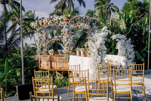 a wedding ceremony with chairs and a floral arch at Bintana sa Paraiso Binunsaran in Mambajao