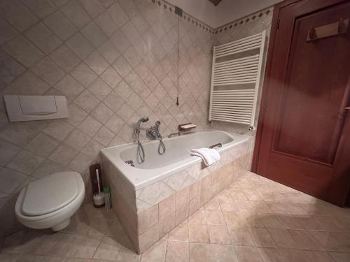 a bathroom with a bath tub and a toilet at Mida & Lino' s House casa rustica in Solagna