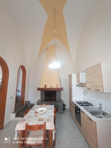 a kitchen with a table and a stove top oven at Casa di Angela in Sannicola