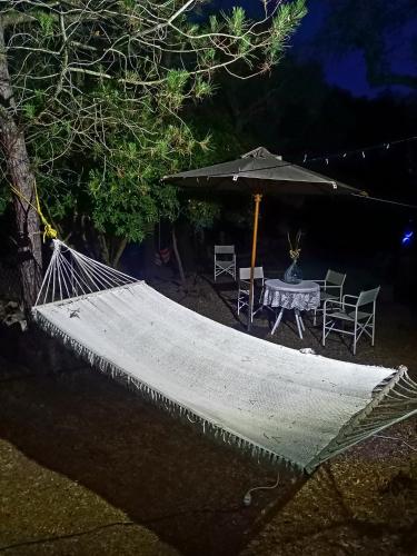 a hammock and an umbrella and a table and chairs at Azienda Agricola Veldidonna in Aggius