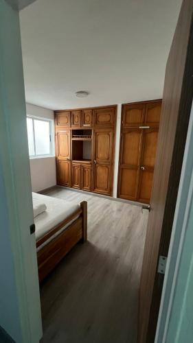 a small room with a bed and wooden cabinets at Apartamento Simón Bolívar in Itagüí