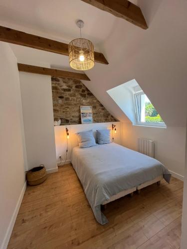 a bedroom with a large bed in a attic at La longère de Ty Pors in Combrit