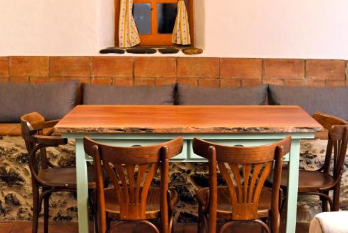 a table with four chairs and a mirror on the wall at Cerro Da Fontinha in São Teotónio