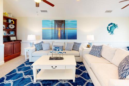 a living room with a white couch and a table at Sea Nine #C9SC-H in Hatteras