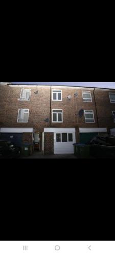 a large brick building with a white garage at Low Budget Studio Room in Woolwich