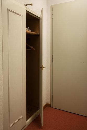 an open door to a closet in a room at Hôtel de la Poste Martigny - City Center in Martigny-Ville
