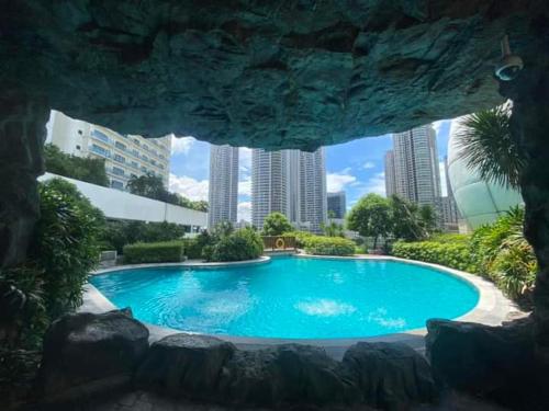 a large swimming pool in a city with tall buildings at Aveline Suites Sunrise 2bedroom in Manila