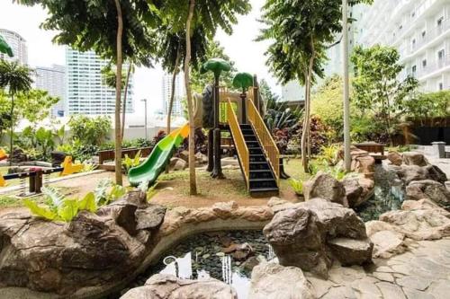 a playground with a slide in a park at Aveline Suites Sunrise 2bedroom in Manila