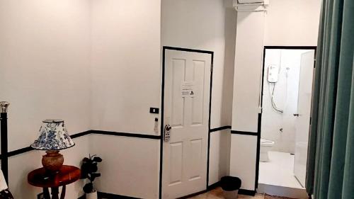 a white room with a door and a lamp at The Character Yaowarat - คาแรคเตอร์ เยาวราช in Bangkok