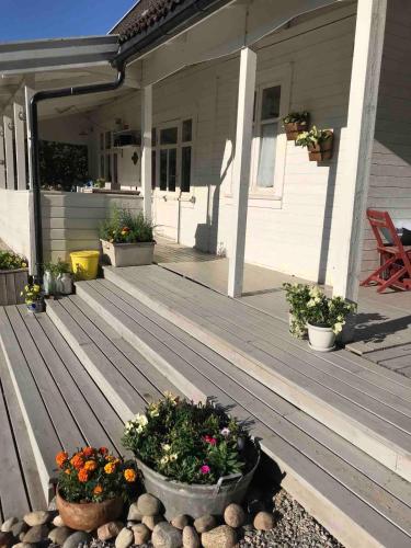 a porch of a house with two pots of flowers at Charming Cottage near Beach & Nature in Sarpsborg