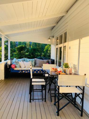 a porch with a table and chairs and a couch at Charming Cottage near Beach & Nature in Sarpsborg