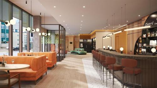 a restaurant with orange chairs and a bar at Hyatt Place Tallinn in Tallinn