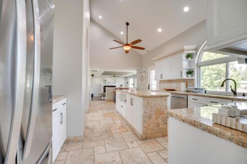 a kitchen with white cabinets and a ceiling fan at Private Hot Tub Home Near Moses Lake Access in Moses Lake
