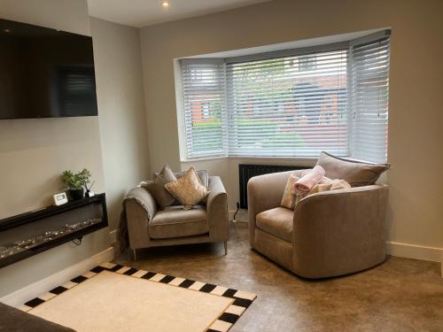 a living room with two chairs and a window at 3 Bedroom home, with 4 beds, parking, walk to station & town centre families and business visitors welcome in Ormskirk