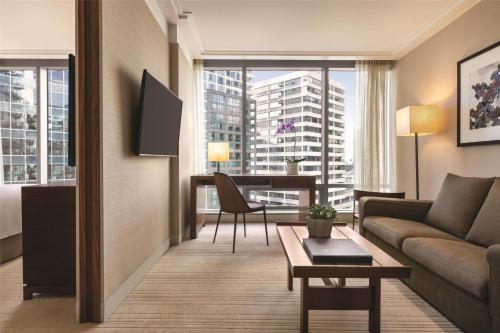 a living room with a couch and a table at Hyatt Vancouver Downtown Alberni in Vancouver