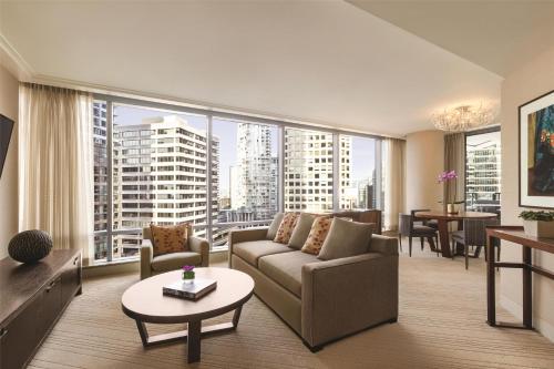 a living room with a couch and a large window at Hyatt Vancouver Downtown Alberni in Vancouver
