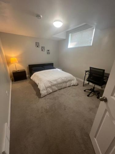 a bedroom with a bed and a desk and a chair at Cozy Private Suite with Parking near restaurants in Regina