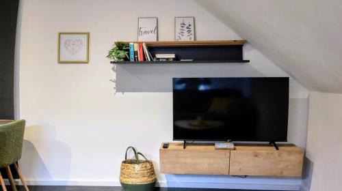 a living room with a flat screen tv on a wall at Komfort FeWo l Moselstay l maximal 4 Personen und Baby I Brauneberg Mosel I WIFI I in Brauneberg