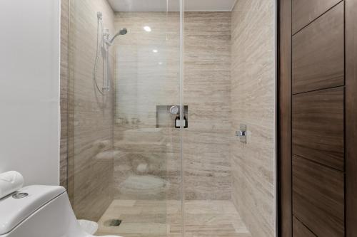 a bathroom with a glass shower with a toilet at 2 BR Apartment in Marina Condo in Cancún