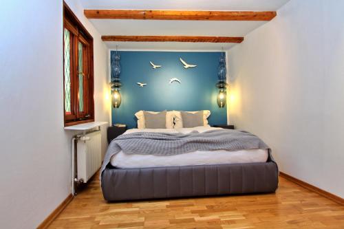 sypialnia z dużym łóżkiem z niebieską ścianą w obiekcie Apartments Constance w Konstancji