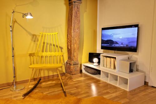 a living room with a yellow chair and a flat screen tv at Apartments Constance in Konstanz