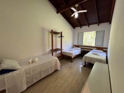 a room with two beds and a window at 400m da Praia | Roupa de cama/banho in Pauba