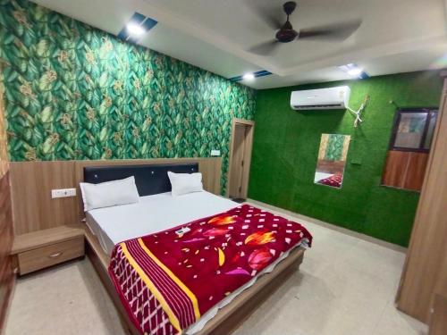 a bedroom with a bed with a green wall at TRPOTELS Shree Ji in Gwalior