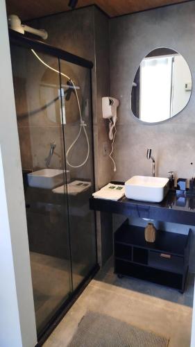 a bathroom with two sinks and a shower with a mirror at Apartamento na Cobertura BeiraMar Pajuçara in Maceió