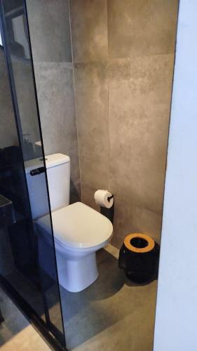 a bathroom with a toilet and a glass shower at Apartamento na Cobertura BeiraMar Pajuçara in Maceió