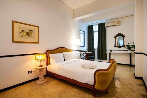 a bedroom with a bed and a table and a lamp at The Character Yaowarat - คาแรคเตอร์ เยาวราช in Bangkok