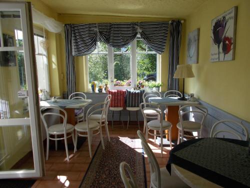una sala da pranzo con tavoli, sedie e una finestra di Villa Meteor a Mariánské Lázně