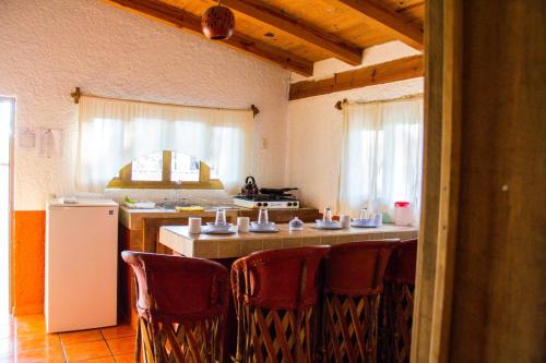 a kitchen with a table with chairs and a refrigerator at Cabañas RuizSeñor in Mazamitla