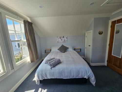 a bedroom with a bed with two pillows on it at Gorgeous cottage near hospital, with garage in Wellington