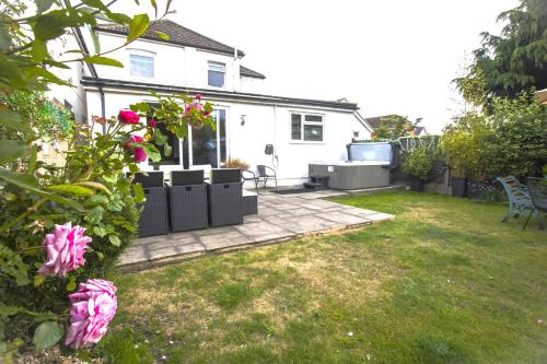 a yard with a white house with a patio at Dolphin Retreat close to Beaches and Harbour in Poole