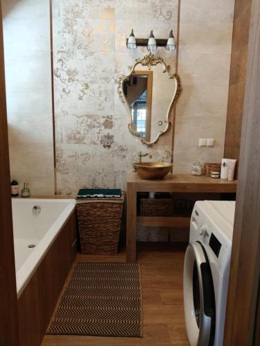 a bathroom with a tub and a sink and a mirror at Słoneczne apartamenty Zator blisko Energylandii in Zator