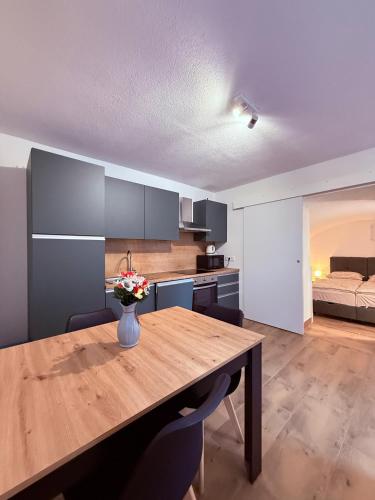 a kitchen with a wooden table with a vase of flowers on it at AGRO house LIKA in Gospić