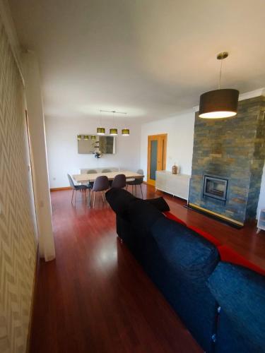 a living room with a blue couch and a table at Douro & Sabor Escape in Torre de Moncorvo
