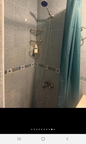 a shower in a bathroom with a blue shower curtain at Квартира in Aghk'ilisa