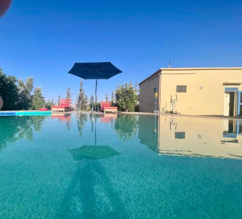 an umbrella sitting in the middle of a pool of water at Agafay Olivium 