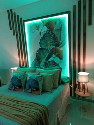 a bedroom with a bed with a green head board at Cabañas Mantas in Tarcoles