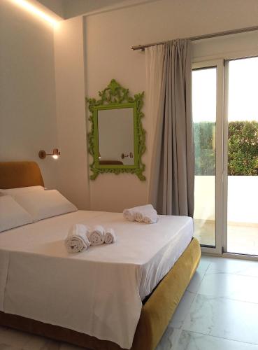 two towels on a bed in a room with a window at Salacia rooms in Avola