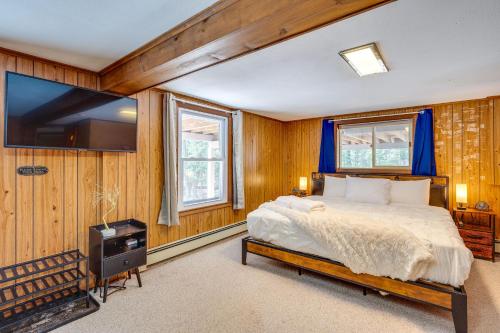 a bedroom with a bed and a flat screen tv at Haverhill Mtn Retreat Hike, Ski, Relax in Hot Tub in Woodsville