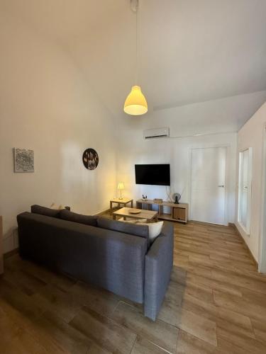 a living room with a couch and a flat screen tv at Casas La Aldea Suites Plaza in La Aldea de San Nicolas