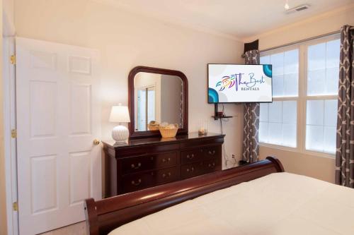 a bedroom with a bed and a mirror and a dresser at Pier Pleasure in Folly Beach