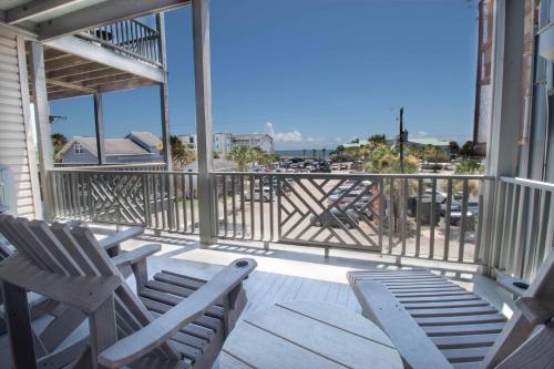 a porch with chairs and a view of the ocean at Pier Pleasure in Folly Beach