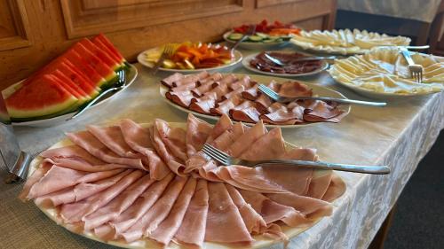 a table with many plates of meat and fruit at Penzion SATELIT in Deštné v Orlických horách