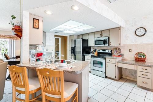 a kitchen with a island with chairs and a counter top at 3 Mi to Weeki Wachee Springs SP Poolside Oasis! in Spring Hill