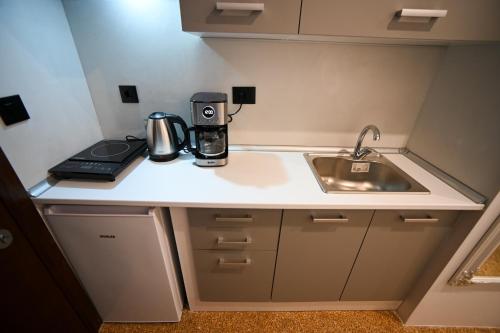 a kitchen counter with a coffee maker and a sink at Hera Elegant Suite by Zeus Suites in Athens