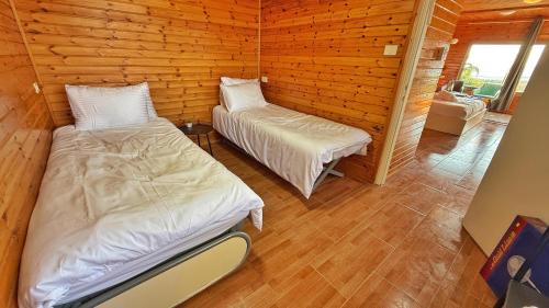 a room with two beds in a log cabin at I love sky in Manot